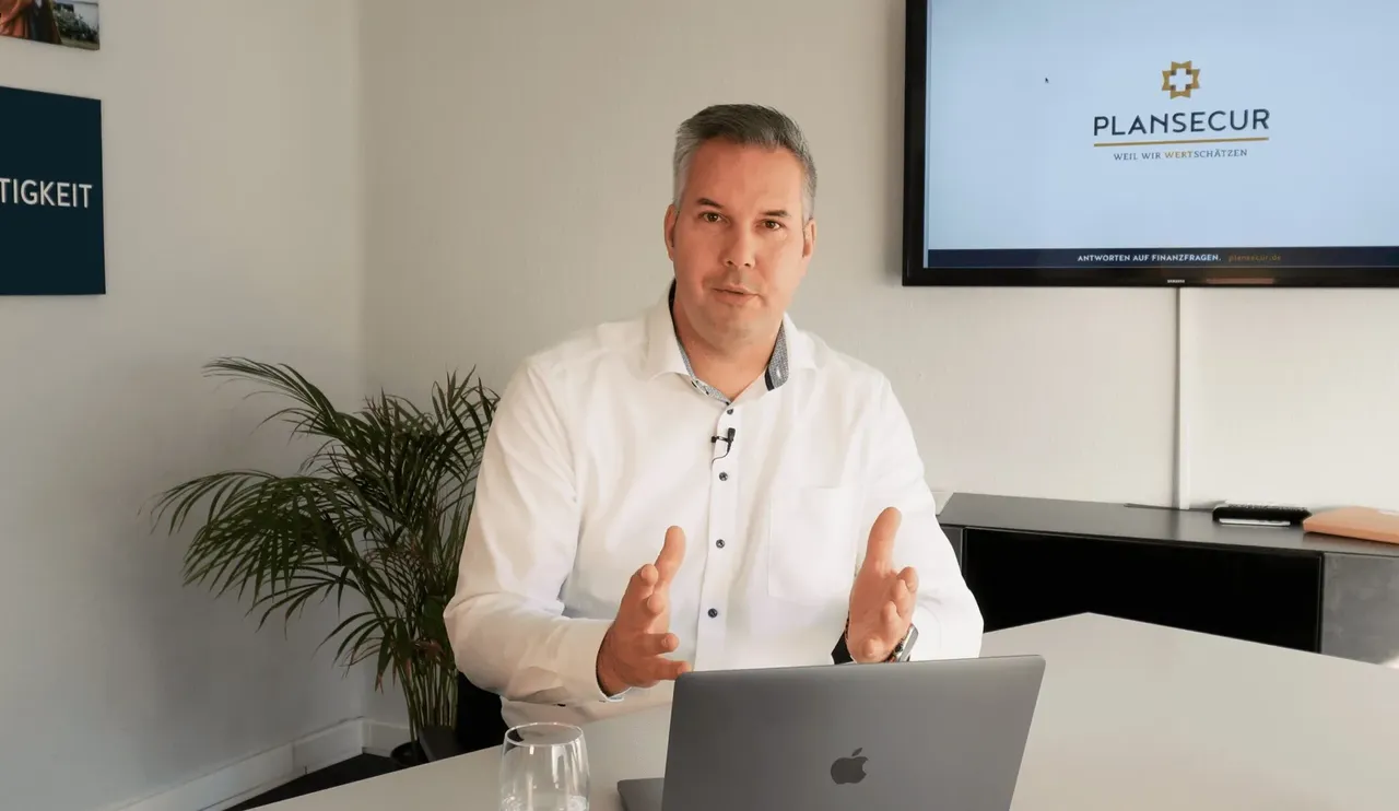 Thorsten Vortmeyer bei der Erläuterung eines schriftlichen Finanzplans am Schreibtisch